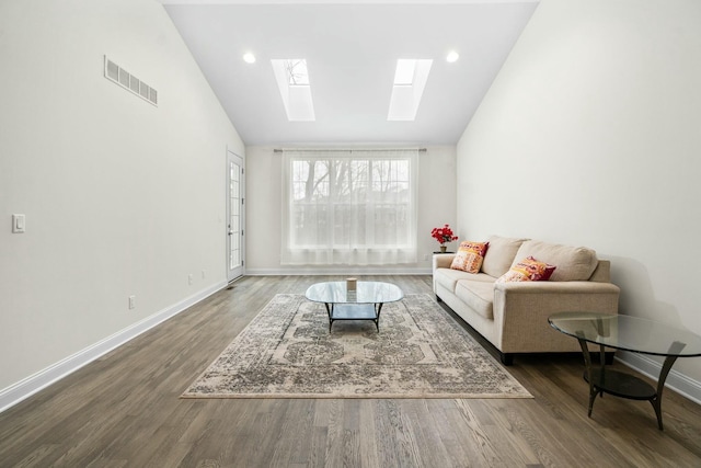 living area with lofted ceiling with skylight, visible vents, wood finished floors, and baseboards