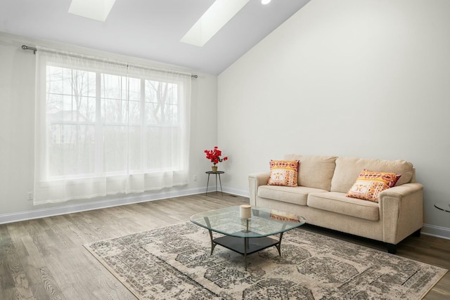 living room with baseboards, wood finished floors, and lofted ceiling with skylight