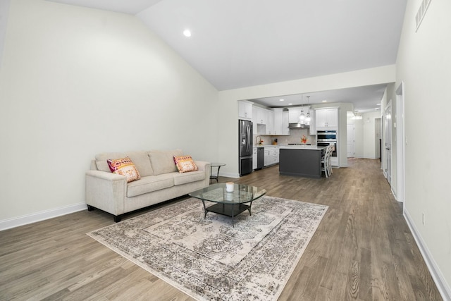 living area featuring wood finished floors, visible vents, and baseboards