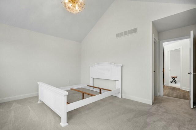 unfurnished bedroom with visible vents, baseboards, an inviting chandelier, carpet, and high vaulted ceiling