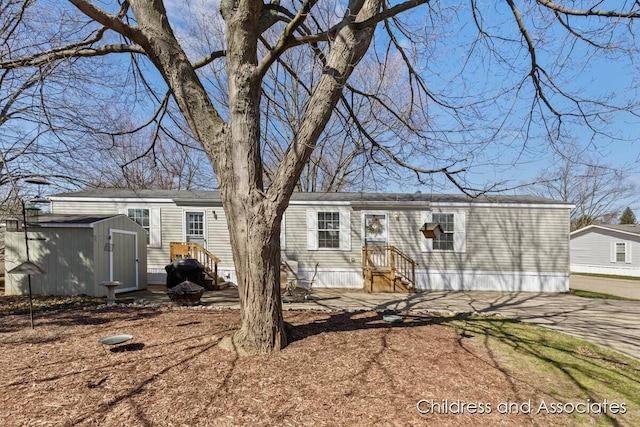 view of front of property with an outdoor structure and a shed