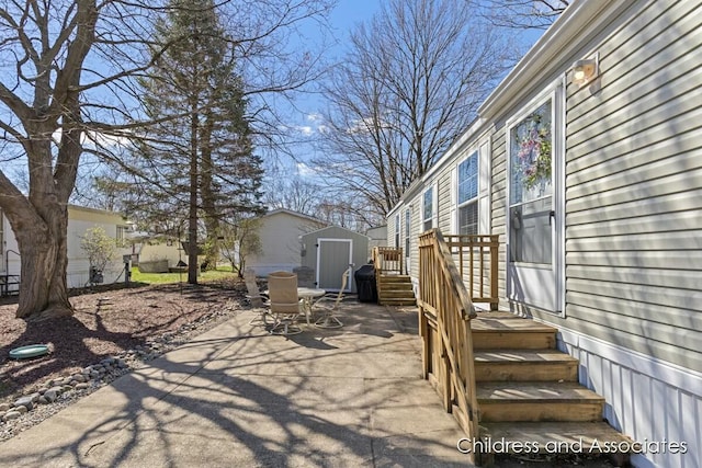 view of patio featuring outdoor dining area, an outbuilding, and a shed
