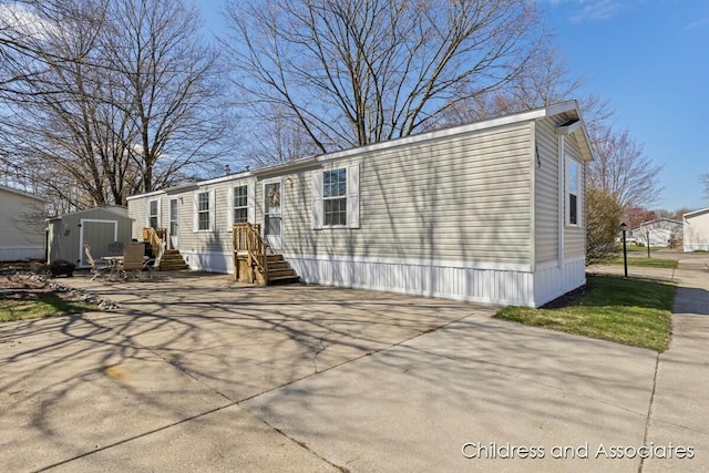 back of property featuring an outdoor structure, a shed, and concrete driveway