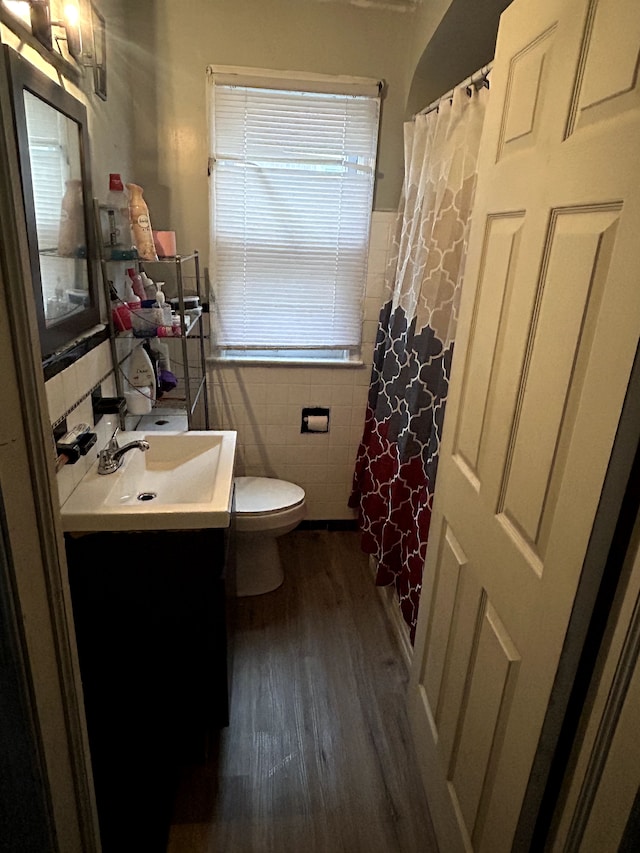 12541 Camden St, Detroit, MI 48213 - bathroom featuring a wainscoted wall, toilet, tile walls, wood finished floors, and vanity
