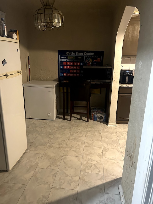 12541 Camden St, Detroit, MI 48213 - dining space with arched walkways, an inviting chandelier, and marble finish floor