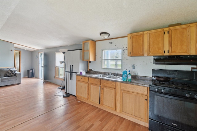 kitchen featuring a sink, a textured ceiling, light wood-style flooring, black range with gas cooktop, and under cabinet range hood