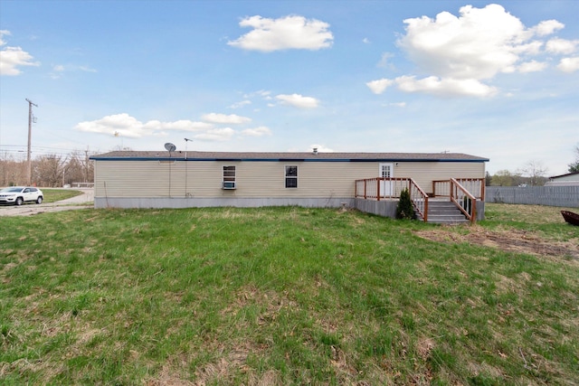 back of property featuring a yard, a deck, and fence
