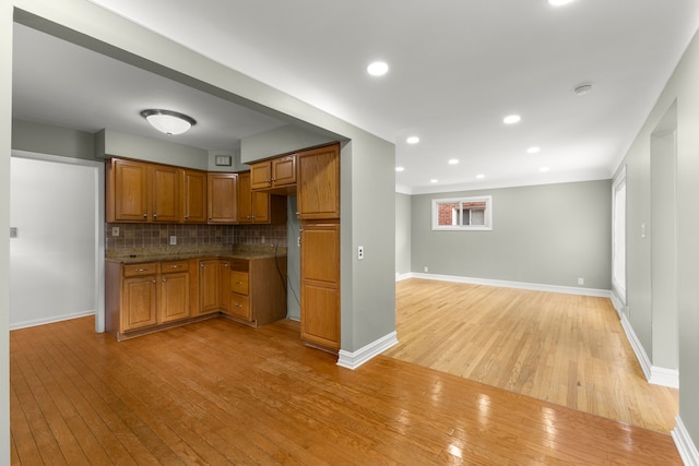 15167 Keppen Ave, Allen Park, MI 48101 - kitchen with decorative backsplash, baseboards, brown cabinetry, and light wood-style floors