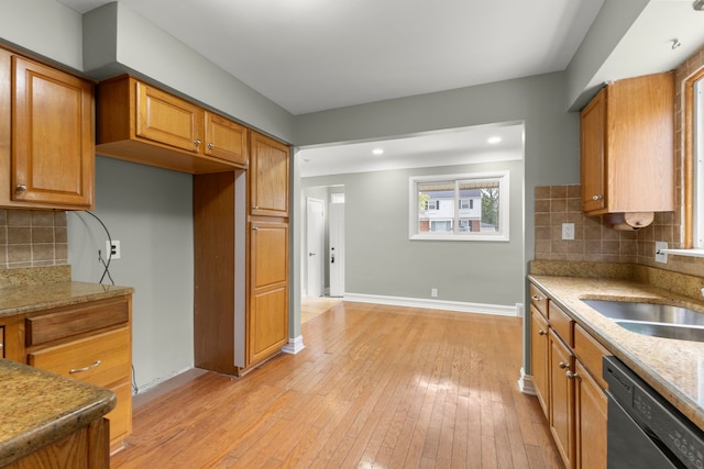 15167 Keppen Ave, Allen Park, MI 48101 - kitchen with brown cabinetry, decorative backsplash, baseboards, dishwashing machine, and light wood-type flooring