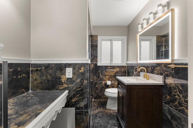 15167 Keppen Ave, Allen Park, MI 48101 - bathroom with vanity, toilet, marble finish floor, a wainscoted wall, and tile walls