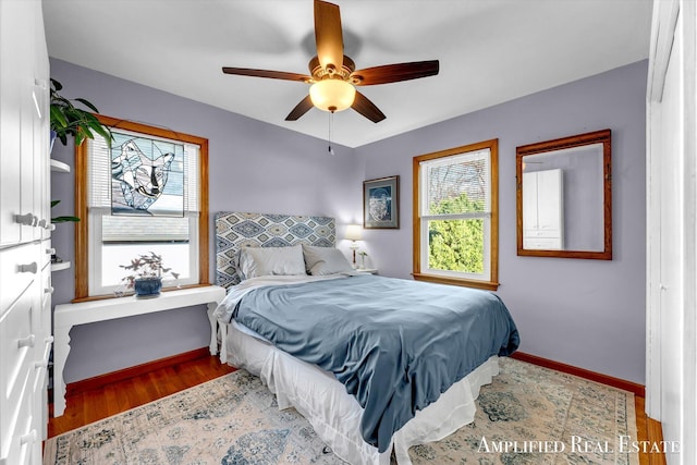 bedroom with baseboards, wood finished floors, and a ceiling fan