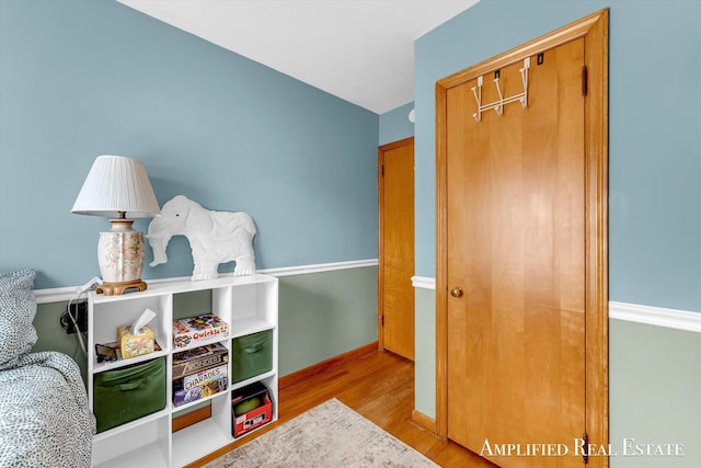 game room with baseboards and wood finished floors