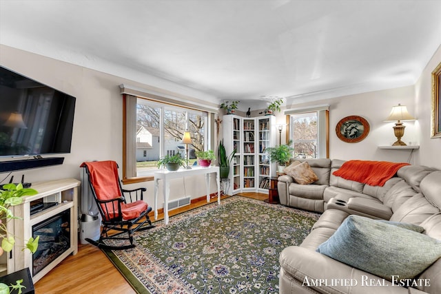 living room with visible vents, wood finished floors, and a healthy amount of sunlight