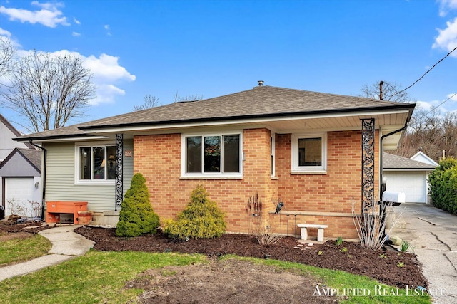 view of front of property with driveway, roof with shingles, brick siding, and a garage