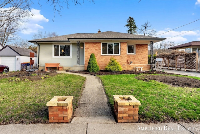 bungalow-style house with a chimney, a front yard, a shingled roof, and brick siding