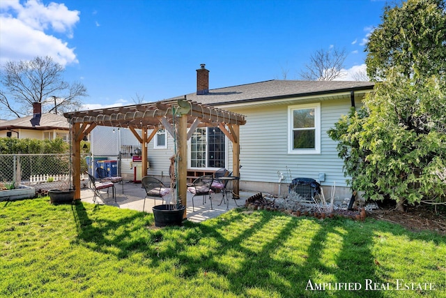 rear view of property featuring a yard, a pergola, a patio, and a chimney