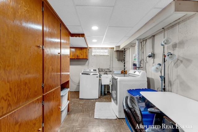 washroom with a sink, recessed lighting, cabinet space, and washing machine and dryer