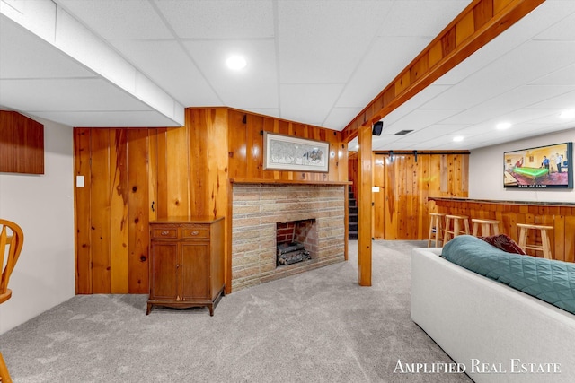 living area featuring wood walls, a bar, and carpet