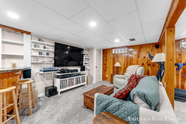 living room with wooden walls, recessed lighting, carpet flooring, and visible vents