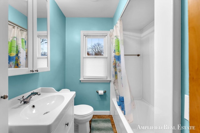 bathroom featuring toilet, a wealth of natural light, vanity, and baseboards