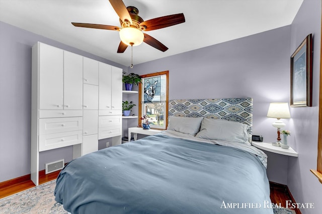 bedroom with baseboards, visible vents, wood finished floors, and ceiling fan
