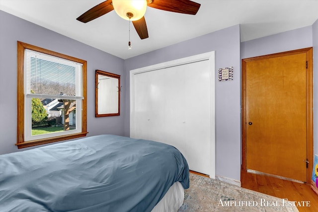 bedroom with a ceiling fan, light wood-style flooring, and a closet
