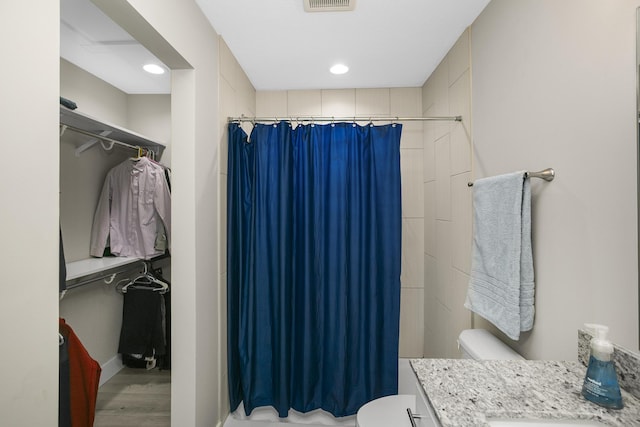 full bathroom with a shower with curtain, vanity, toilet, visible vents, and wood finished floors