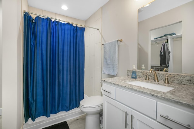 bathroom with toilet, wood finished floors, and vanity