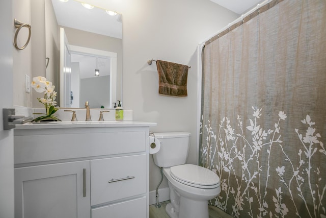 bathroom featuring toilet, vanity, and a shower with shower curtain