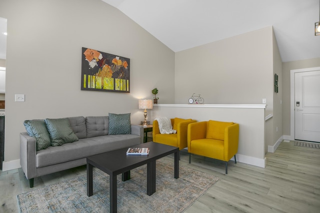 living area with lofted ceiling, wood finished floors, and baseboards