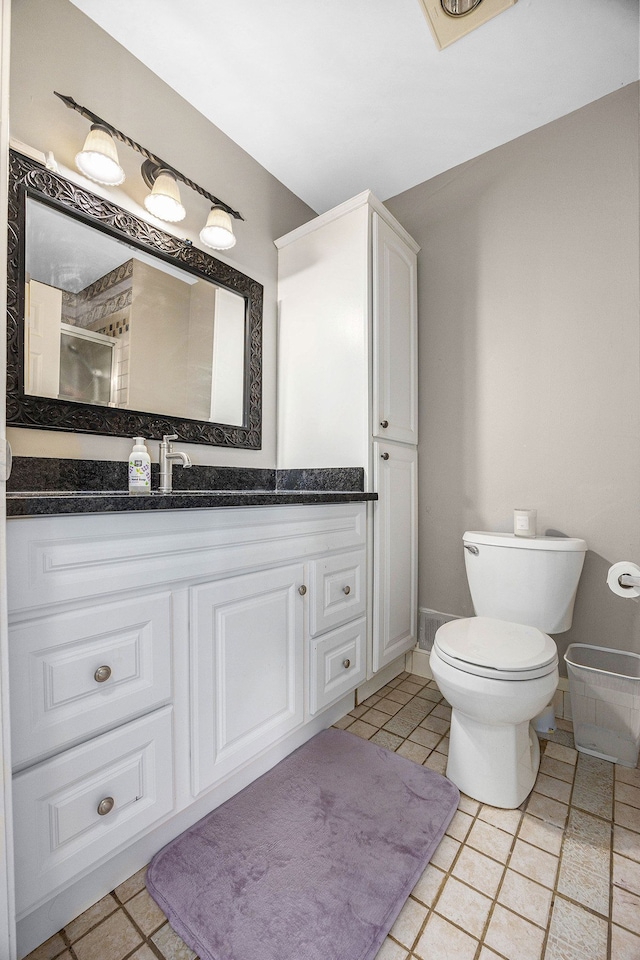 bathroom featuring toilet, tile patterned floors, and vanity