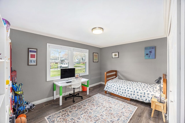 bedroom featuring crown molding, baseboards, and wood finished floors