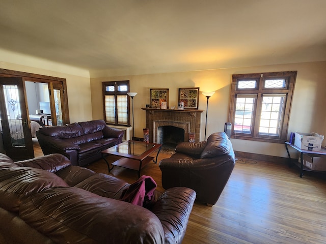 living room with baseboards, a fireplace, and wood finished floors
