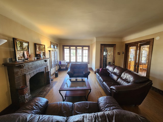 living room with wood finished floors and a tile fireplace