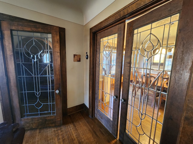entrance foyer featuring baseboards, french doors, wood finished floors, and a wealth of natural light