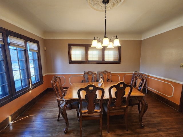 dining space with baseboards, a notable chandelier, and wood finished floors