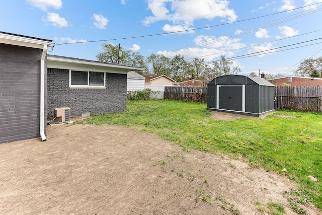 view of yard with an outdoor structure, central AC, a fenced backyard, and a storage unit
