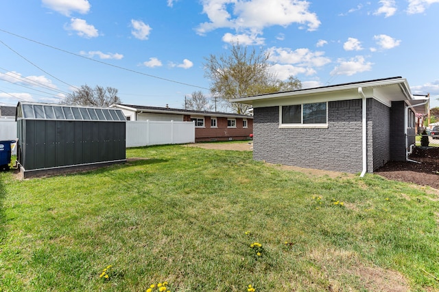 view of yard with a storage shed, fence, and an outdoor structure