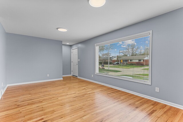 unfurnished room with baseboards and light wood-style flooring