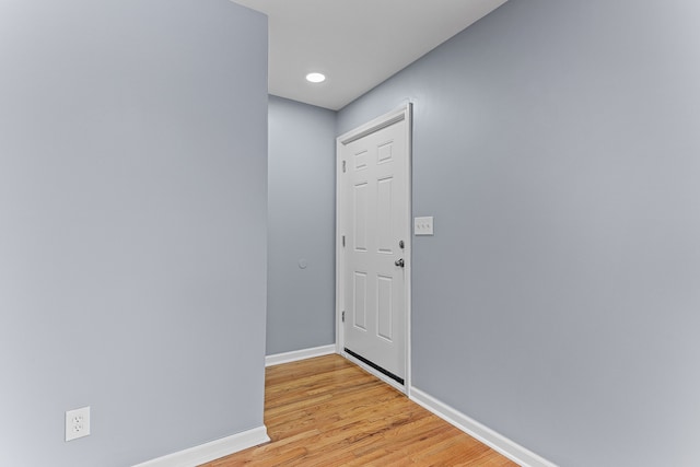 doorway to outside featuring baseboards and light wood-type flooring