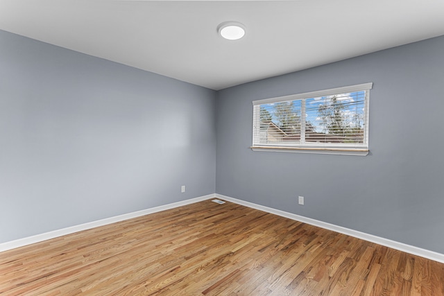 empty room with baseboards and wood finished floors