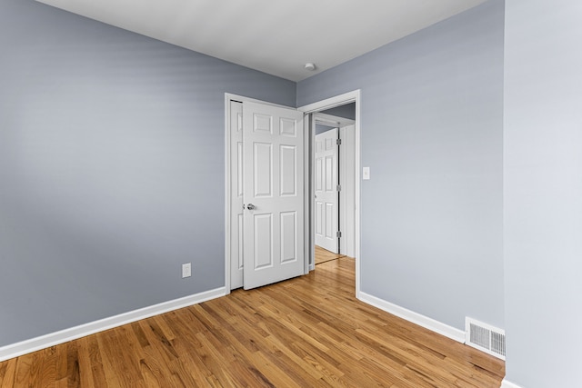 unfurnished bedroom featuring baseboards, visible vents, and light wood-type flooring