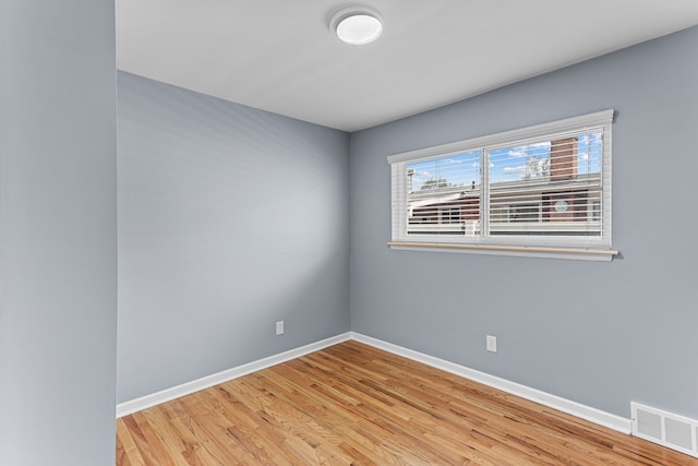 empty room with baseboards, visible vents, and light wood-type flooring