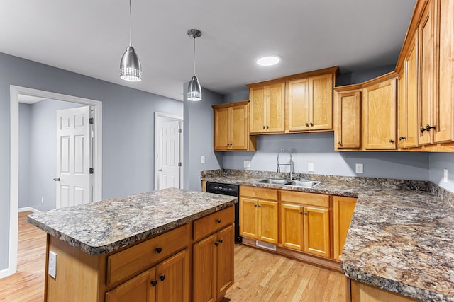 kitchen featuring dark countertops, a sink, dishwasher, light wood-type flooring, and a kitchen island