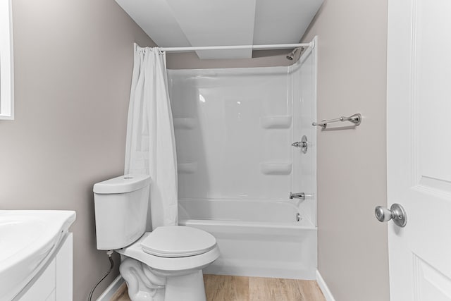 full bathroom with vanity, wood finished floors, toilet, baseboards, and shower / bathtub combination with curtain