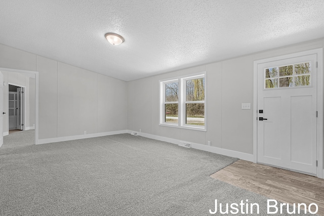 foyer with a textured ceiling, visible vents, and a wealth of natural light