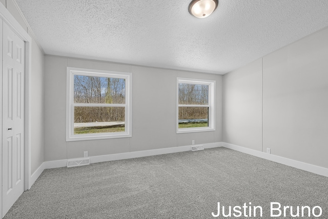 unfurnished bedroom featuring visible vents, a textured ceiling, and carpet