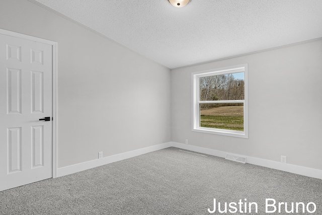 carpeted spare room featuring baseboards, visible vents, and a textured ceiling
