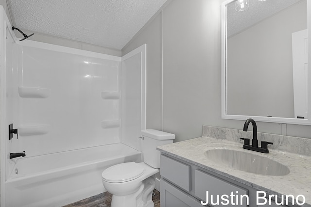 full bath featuring toilet, a textured ceiling, tub / shower combination, and vanity