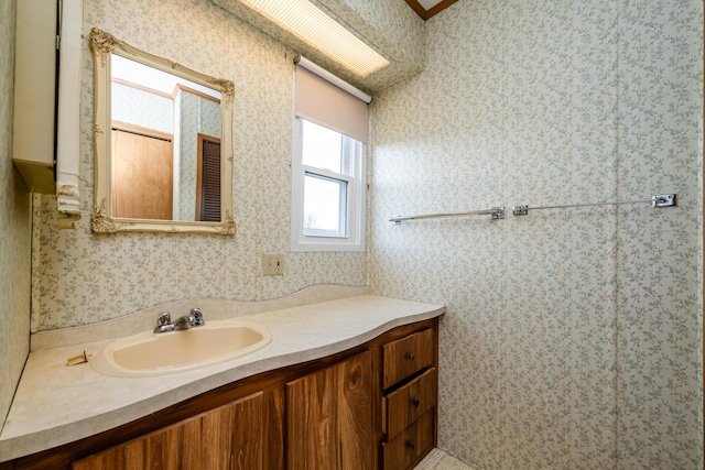 bathroom featuring vanity and wallpapered walls